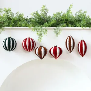 Detailed view of velvet and glitter Christmas ornaments hanging from a festive mantel