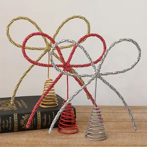 Détail de cimiers de sapin en forme de nœud avec strass brillants en rouge or et argent