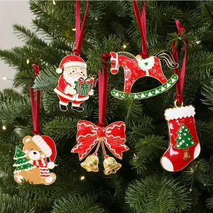 Detail view of festive enamel Christmas ornaments hanging on a green pine tree branch