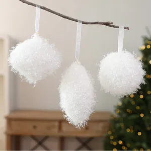 Vue détaillée de trois décorations de Noël blanches et duveteuses aux formes géométriques