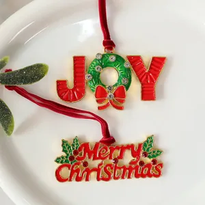 Macro view of festive alloy JOY and Merry Christmas pendants with red velvet ribbons