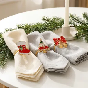 Detailansicht festlicher Serviettenringe mit Weihnachtsbaum und Socken auf Tisch.