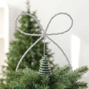 Gros plan sur une décoration de sommet de sapin en forme de nœud argenté pailleté