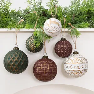 Primo piano di palline di Natale vintage con trame intricate e accenti dorati.