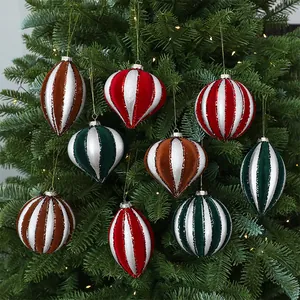 Detailed view of assorted velvet Christmas ornaments on a pine tree