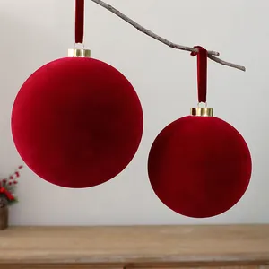 Close-up of elegant red flocked Christmas balls hanging from a rustic wooden branch
