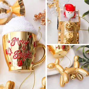 Dettaglio decorazioni natalizie dorate con cane palloncino e tazza Merry & Bright