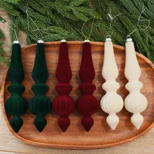 Lot de 6 décorations de Noël en velours vert, rouge et crème sur un plateau en bois.
