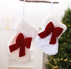 Primer plano de calcetines de Navidad blancos con lentejuelas y grandes lazos de terciopelo rojo