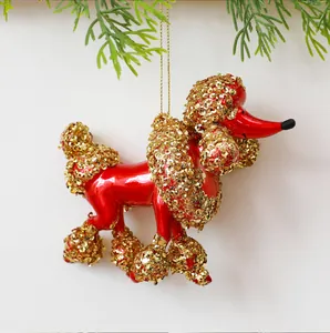 Vista dettagliata di un ornamento a forma di barboncino rosso e oro con paillettes.