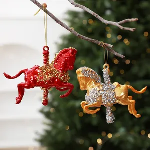 Close-up detail of red and gold carousel horse Christmas ornaments hanging on a branch