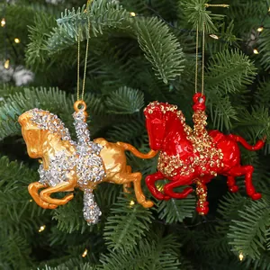 Set of gold and red carousel horse Christmas ornaments hanging on a festive pine tree