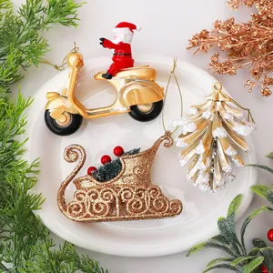 Dettaglio di addobbi natalizi dorati con Babbo Natale su scooter e slitta oro.