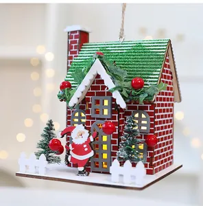 Detailed view of a red wooden Christmas house ornament with Santa and LED lights