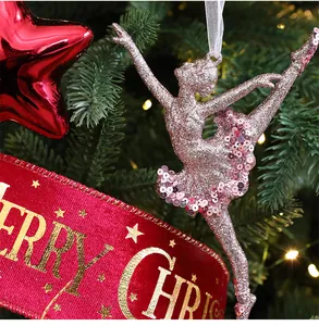 Close-up of a sparkling pink glitter ballerina ornament hanging on a Christmas tree.