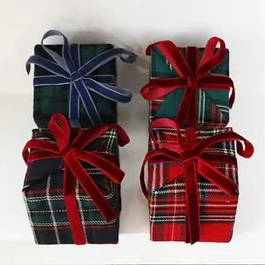 Dettaglio di quattro ornamenti per scatole regalo di Natale a quadri da 8 cm e nastro