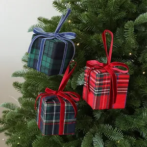 Dettaglio di scatole regalo in tessuto scozzese con fiocchi di velluto su un albero