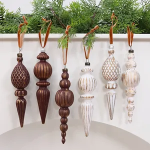 Set of vintage spindle-shaped Christmas ornaments hanging on a fireplace mantel