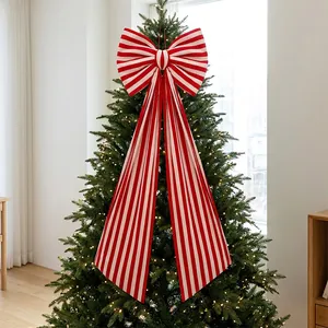Large red and white striped bow topper displayed on a lit Christmas tree for decor.