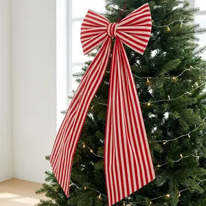Large red and white striped bow hanging as a decorative Christmas tree topper pendant