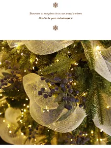 Close-up of decorative artificial blueberry picks on a lit Christmas tree with ribbon