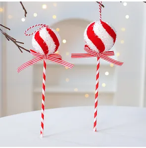 Close-up of festive red and white glitter foam Christmas lollipop ornaments on a table.