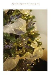 Close-up of decorative simulation blueberry branches on a Christmas tree with warm lights