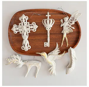 Juego de adornos navideños vintage blancos y dorados sobre una bandeja madera