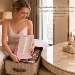 Pink crystal embellished folding makeup mirror in a travel suitcase