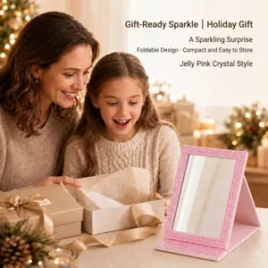 Detailed view of a pink rhinestone-studded folding makeup mirror in a festive gift setting.