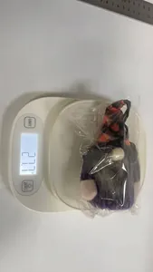 Weight measurement showing a Halloween gnome plush toy at 27.7 grams on a scale