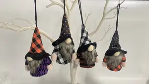 Four cute Halloween gnome plush ornaments hanging on a white tree branch for decoration