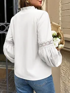 Elegante blusa blanca de manga larga con cuello de volantes y detalles de encaje en las mangas