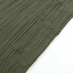 Close-up of textured olive green fabric and pocket on a casual women's jumpsuit