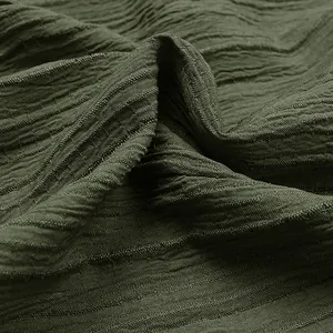 Macro view showing the intricate crinkled texture of dark olive green jumpsuit fabric