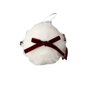 Élégante boule de Noël en fausse fourrure blanche ornée d'un nœud en velours rouge