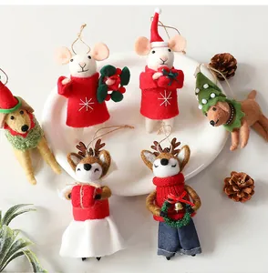 Handmade needle-felted Christmas animal ornaments like mice and deer on a white plate.