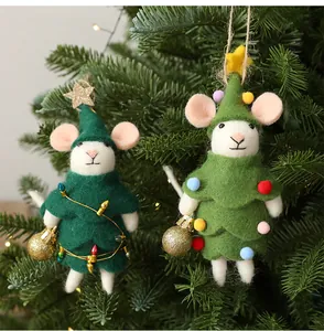 Detail van twee wollen viltmuizen die aan een groene kerstboom hangen voor decoratie