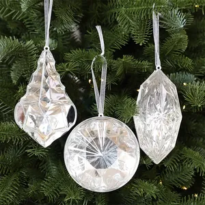 Detalle de adornos navideños de acrílico facetado colgados en un árbol de Navidad verde