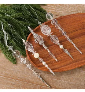 Nahaufnahme eleganter klarer Acryl-Weihnachtsschmuck mit Perlen- und Silberdetails