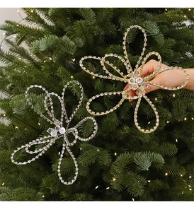 Vue détaillée d'ornements étincelants en acrylique or et argent sur un sapin de Noël festif