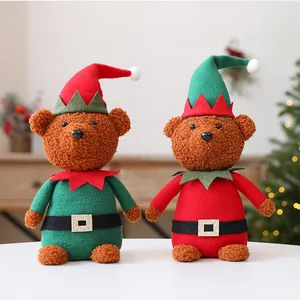 Pair of plush Christmas teddy bears in red and green elf costumes on a white table