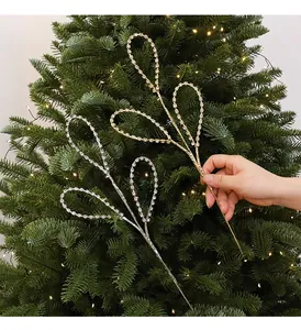 Vue détaillée de branches à strass étincelants sur un sapin de Noël vert