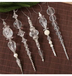 Nahaufnahme von klaren Acryl-Weihnachtsanhängern mit eleganten Details aus Perlen.