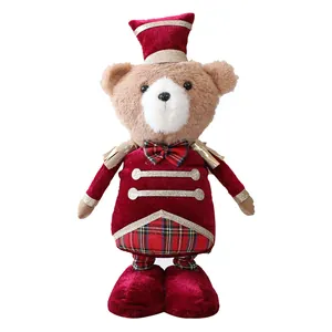 Adorable ours en peluche de Noël debout portant un costume de soldat casse-noisette rouge
