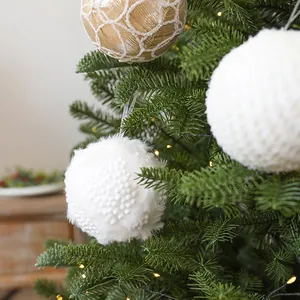 Dekorative 10cm Weihnachtskugeln in Weiß und Gold an einem beleuchteten Weihnachtsbaum