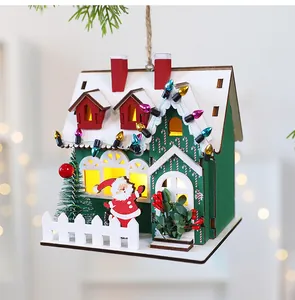 Close-up of a festive wooden Christmas house ornament with glowing windows and LED lights