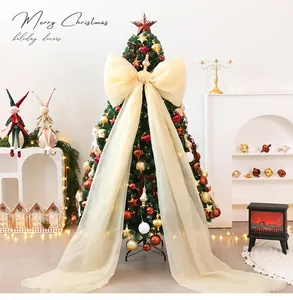 Detailopname van een grote crèmekleurige tule strik op een versierde kerstboom