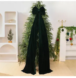 Detailed view of a large dark green velvet Christmas bow decoration with long tails