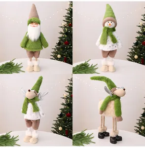 Vier kerstfiguren waaronder de Kerstman en rendieren met groene sjaals voor decoratie.